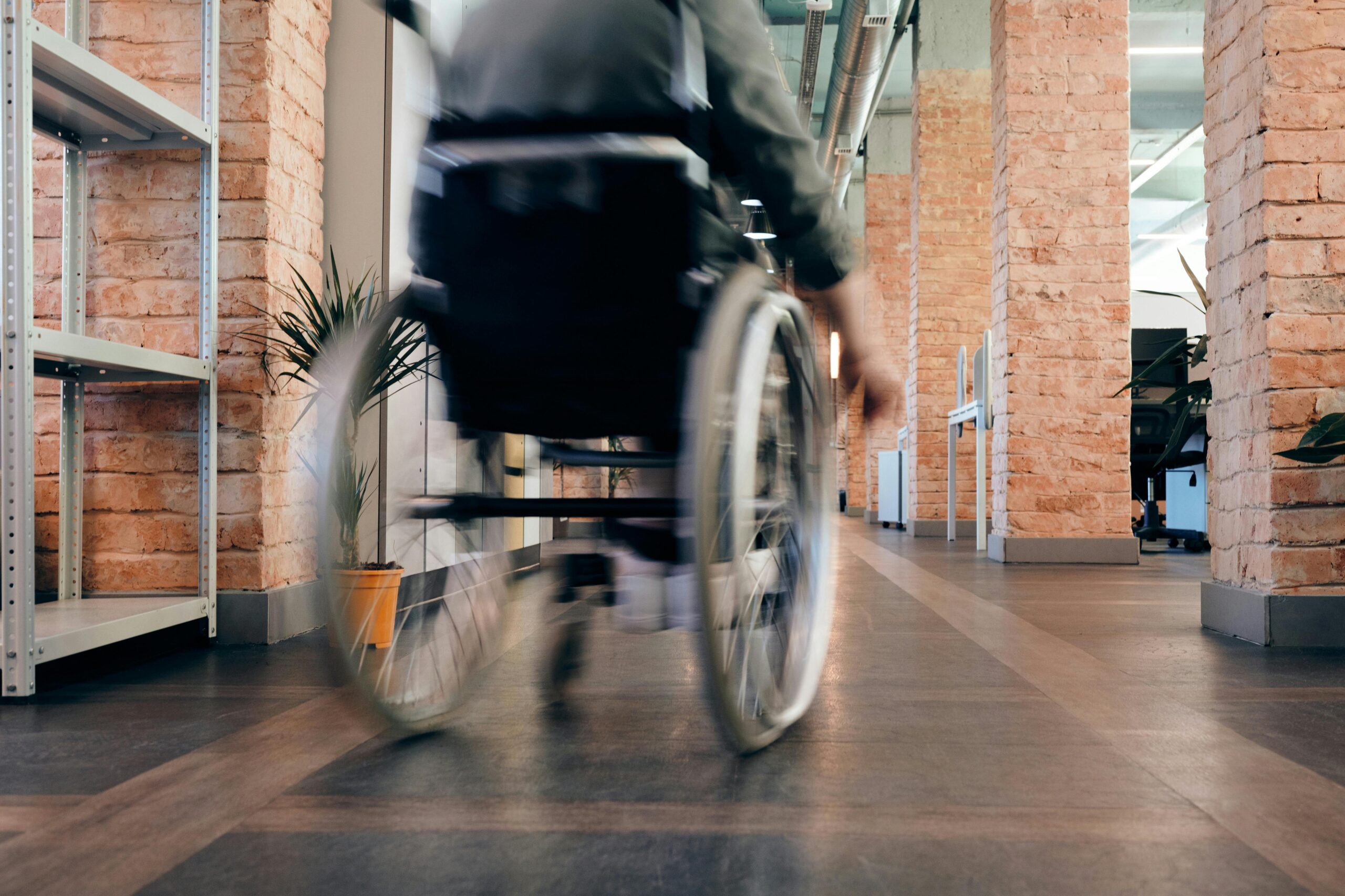 A person in a wheelchair navigates a hallway, showcasing accessibility in movement.